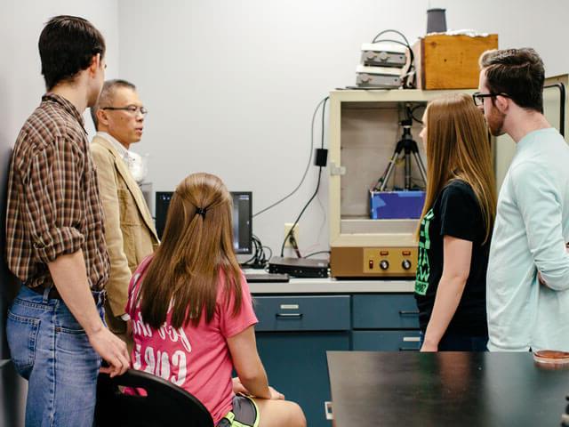 Professor showing students how to use biology equipment